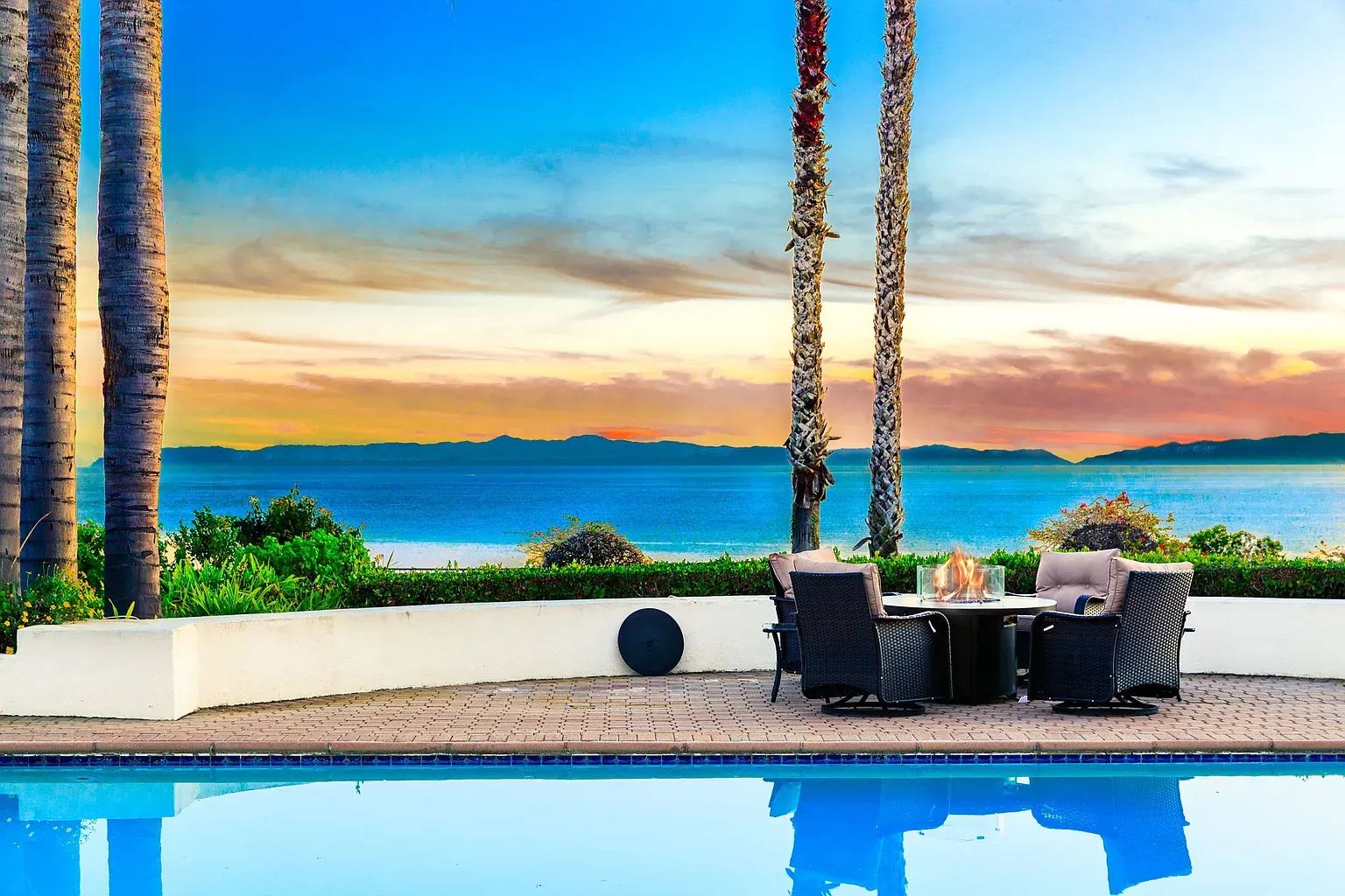Pool terrace with fire pit overlooking the Pacific and Catalina Island at dusk